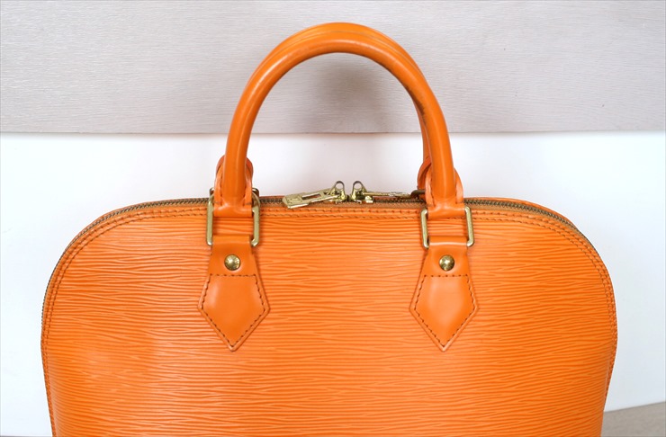 LOUIS VUITTON, an orange Epi leather 'Alma' bag. - Bukowskis